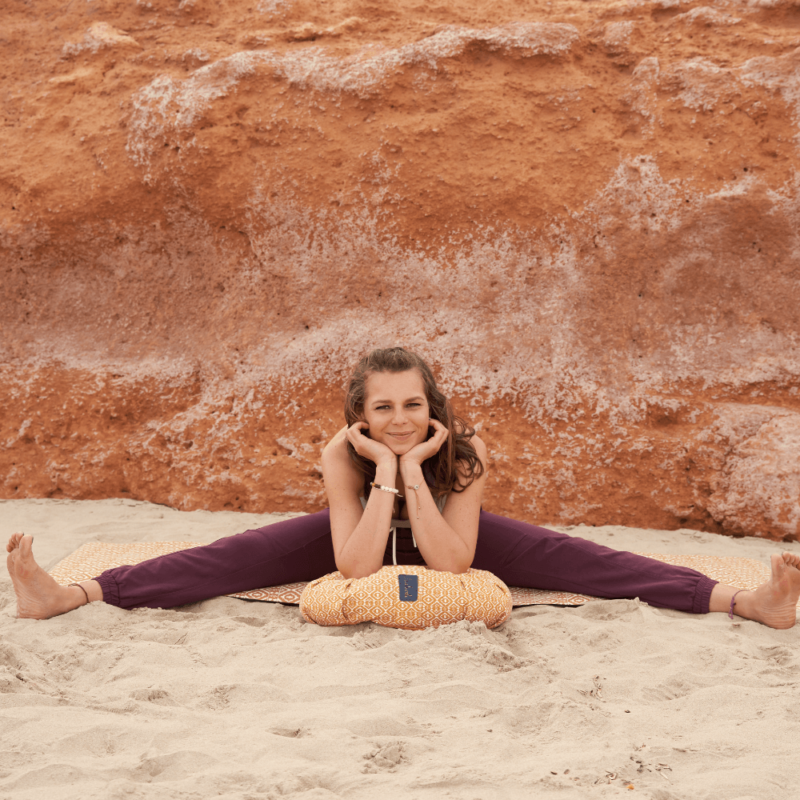Nachhaltiges Yogaoutfit aus Sport BH und Baumwollhose mit Yogakissen auf Yogamatte